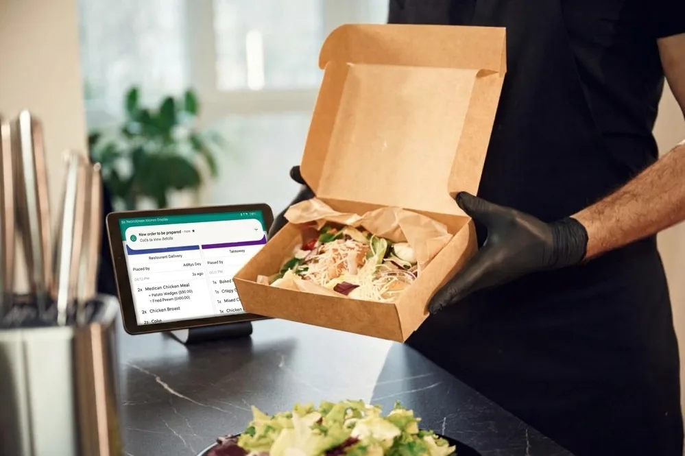 Kitchen order tablet beside food being prepared
